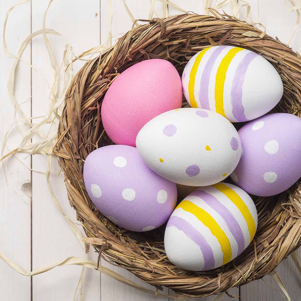 purple pink yellow easter eggs in basket